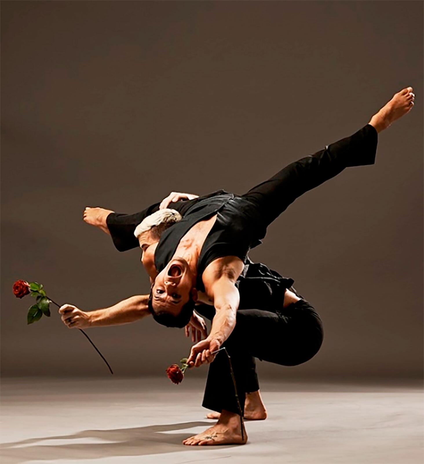 2 dancers in movement on a bare stage