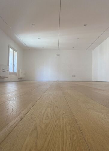 An empty studio space with wooden flooring