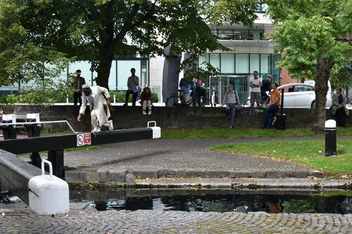 Favour Odusola moving across a canal gate as people watch in the background