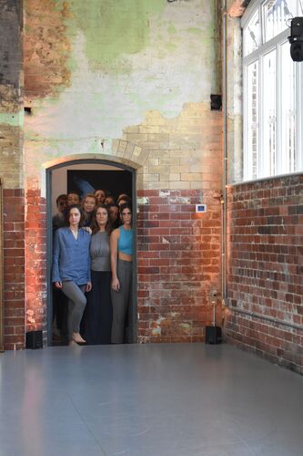 Participants standing in a cluster in the doorway of the CoisCéim studio looking in