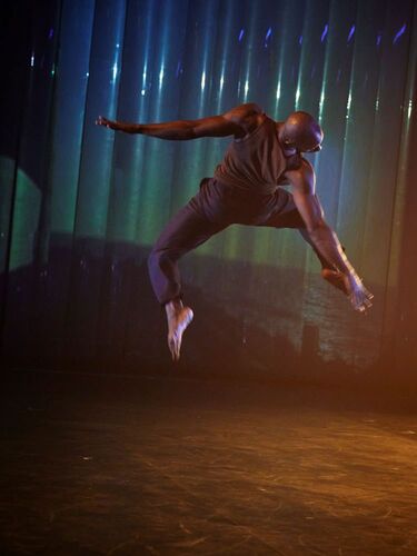 A dancer on stage mid-leap