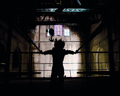 A silhouetted figure in movement in a warehouse