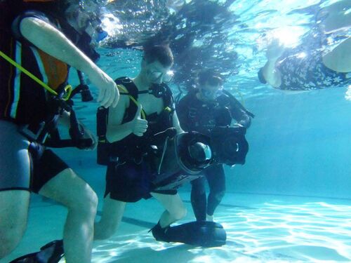 A camera team in swimming togs underwater