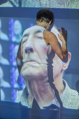 Ivonne Kalter facing the wall with a man's face being projected on her back