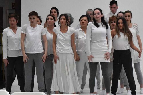 An ensemble of participants all in white dancing