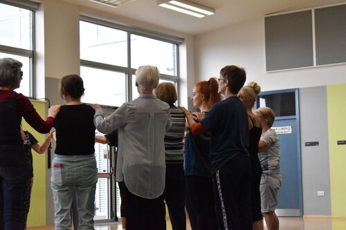 A group of participants in movement in a school hall