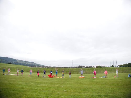 A group of children standing in a line in the distance on a sports field