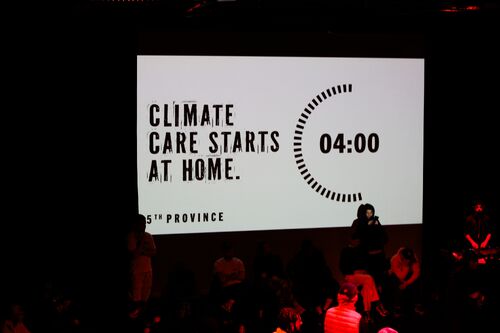 A projection on the wall reading 'CLIMATE CARE STARTS AT HOME' with a timer of 4 minutes