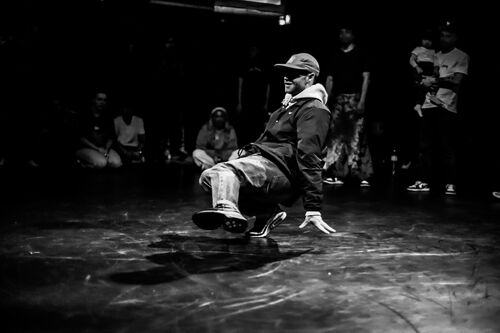 A dancer in movement on the floor in black and white