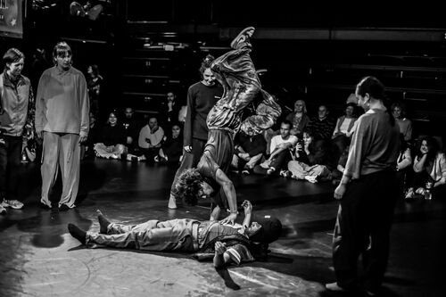 Two dancers in movement with one upside down over the other in black and white