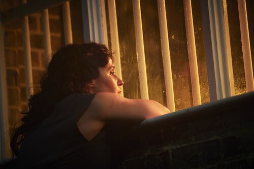 A dancer's thoughtful face looking through the window