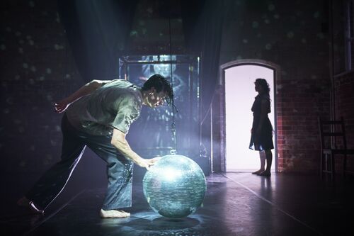 A male dancer stopping the mirror ball on the dance floor and female dancer staying at the doors