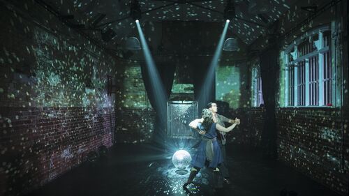 A couple in a movement of Waltz dancing around the mirror ball