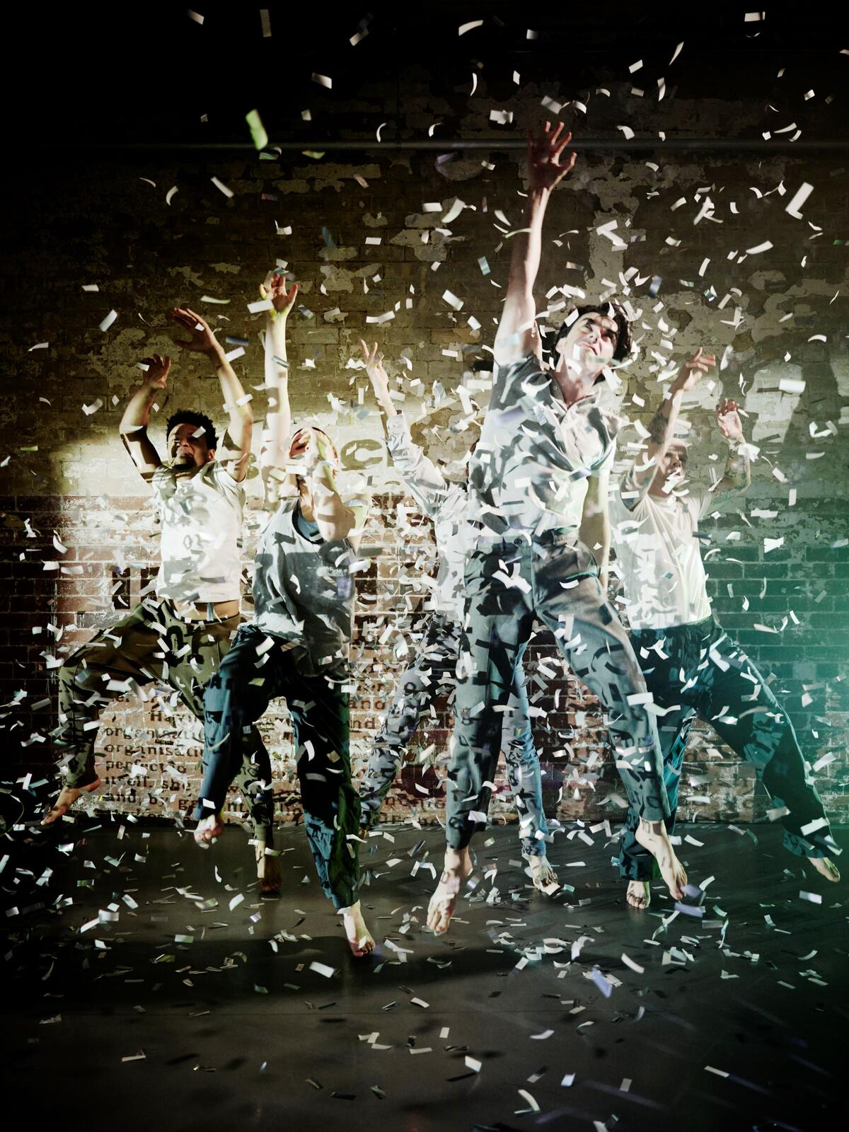 Dancers in a jump and confetti is falling